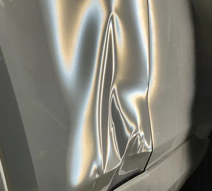 Crease dent along the door of a silver vehicle under PDR reflector lighting at AUTOSTREAM360 Centennial CO