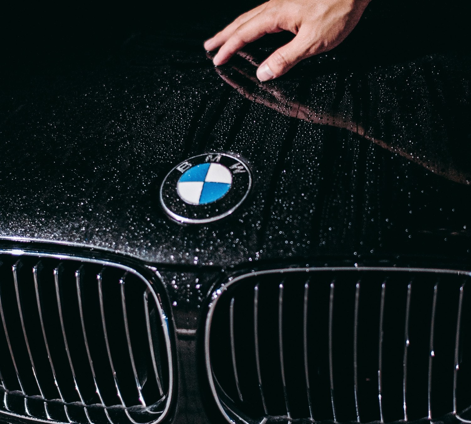 Fresh ceramic coating beading water on a glossy black hood at AUTOSTREAM360