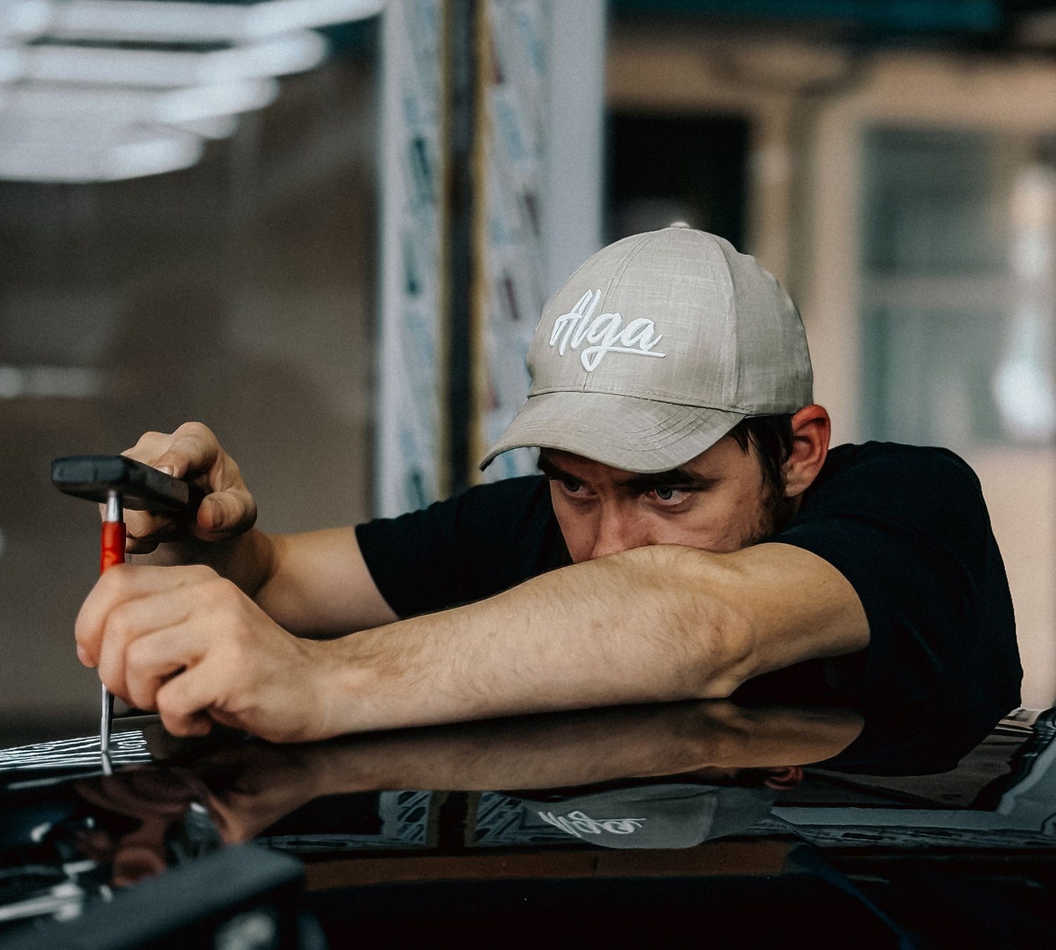 AUTOSTREAM360 technician removing a dent with a paintless dent repair tool, keeping the factory paint intact