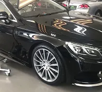 Precision dent pulling rig on a white sports car fender